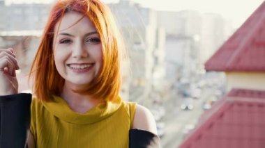 Saçında esen rüzgar ile gülümseyen Kızıl saçlı genç kadın portresi