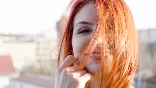 Mulher ruiva com o cabelo em todo o rosto enquanto o vento sopra — Vídeo de Stock