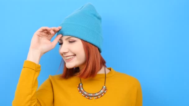 Coole junge Frau trägt einen blauen Hut und spielt damit — Stockvideo