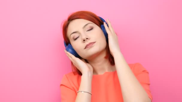 Κοκκινομάλλης γυναίκα απολαμβάνοντας μουσική στο ακουστικό της — Αρχείο Βίντεο