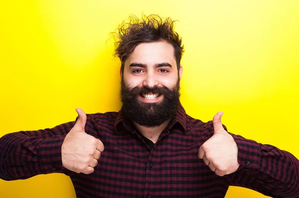 Sonriente hipster barbudo con los pulgares hacia arriba —  Fotos de Stock