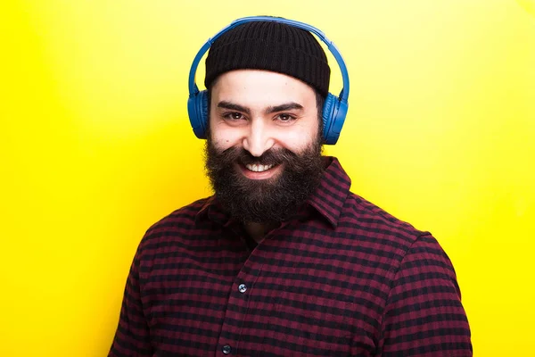 Homem hipster barbudo usando um chapéu preto e ouvindo música — Fotografia de Stock
