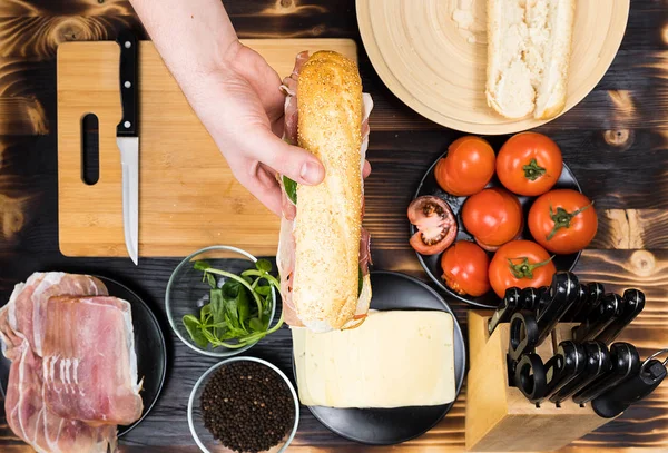 Мужские руки держат сэндвич домашнего приготовления — стоковое фото