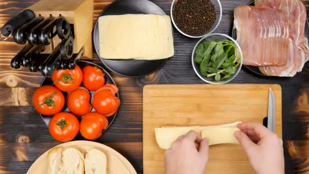 Hacer un sándwich en la cocina sobre tabla de madera — Vídeos de Stock