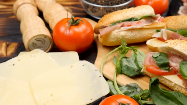 Четыре здоровых и вкусных сэндвича лежат на деревянной доске на столе — стоковое видео