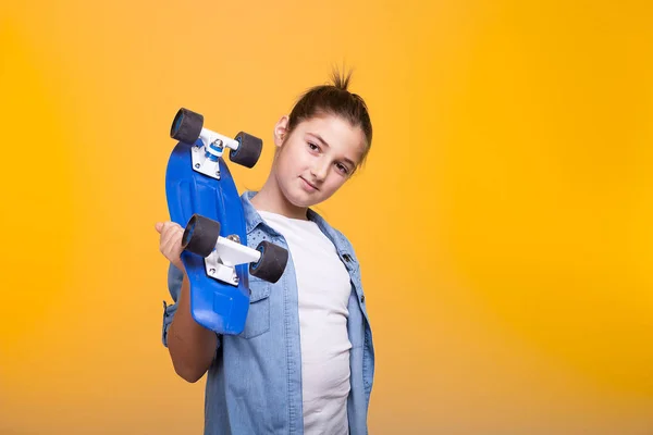 Ευτυχισμένος έφηβος κορίτσι με τη μπλε skateboard πάνω στους ώμους — Φωτογραφία Αρχείου