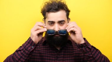 Gülümseyen uzun sakallı hippi onun glasess yüzüne koyar.