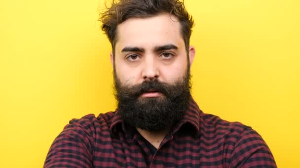 Homem barbudo atraente pisca bobo no fundo amarelo — Vídeo de Stock