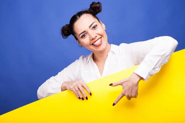 Happy usmívající se žena poiting na žlutý nápis — Stock fotografie