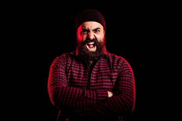 Bearded man screaming in anger on black background Stock Picture