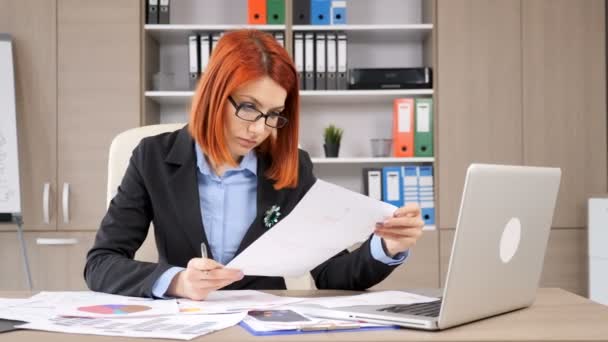 Jonge succesvolle zakenvrouw kijkend naar de grafieken — Stockvideo