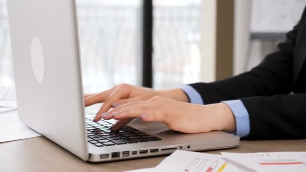 Женские руки, печатающие на клавиатуре ноутбука в офисе — стоковое видео