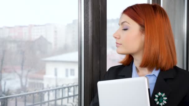 Geschäftsfrau in offizieller Kleidung betritt den Rahmen und schaut durch das Fenster nach draußen — Stockvideo