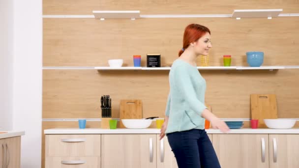 Женщина танцует на кухне — стоковое видео