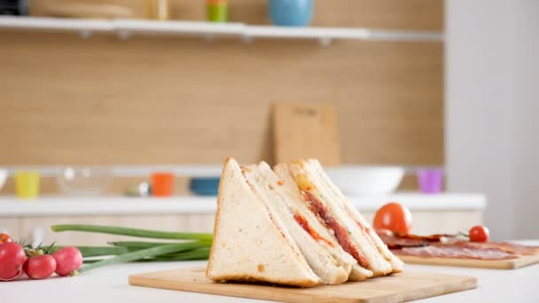 Vier club sandwiches liggend op een houten plank — Stockvideo