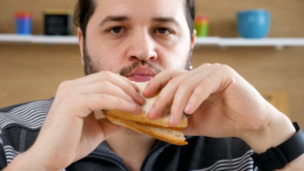 Cerca de hombres barbudos comiendo un sándwich de club — Vídeo de stock