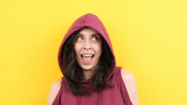 Jovem hipster mulher vestindo um capuz e fazendo caras bobas para a câmera — Vídeo de Stock