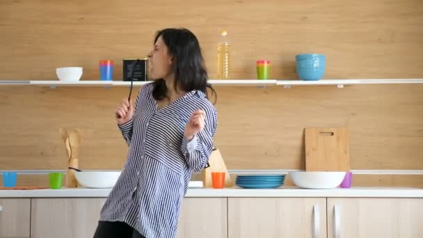 Boldog nő táncol és énekel a konyhában — Stock videók