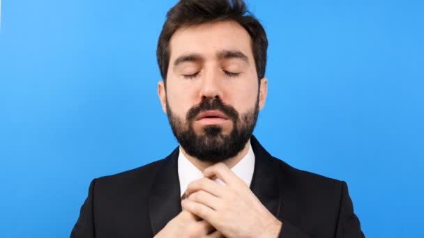 Втомився і напружений бізнесмен розв'язуючи краватку на синьому фоні — стокове відео