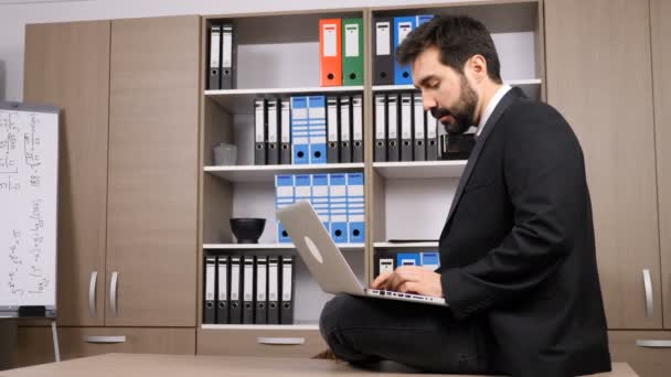 Empresário sentado na mesa e digitando no laptop — Vídeo de Stock