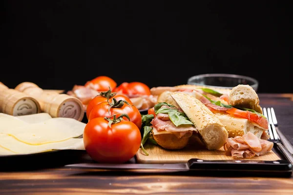 Сэндвичи на деревянной доске на черном фоне — стоковое фото