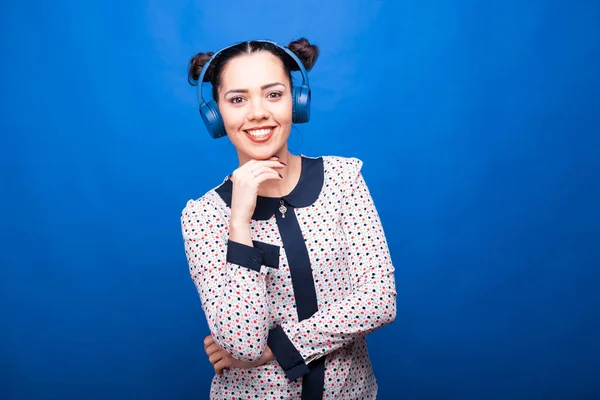 Sorrindo mulher olhando para a câmera e ouvindo música — Fotografia de Stock