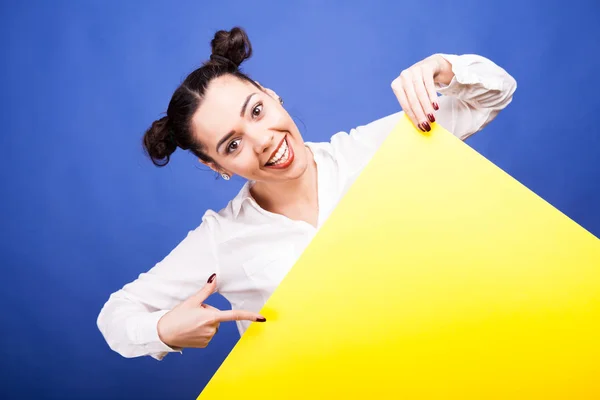 Lächelnde Frau, die mit dem Finger auf gelbem Transparent pocht — Stockfoto