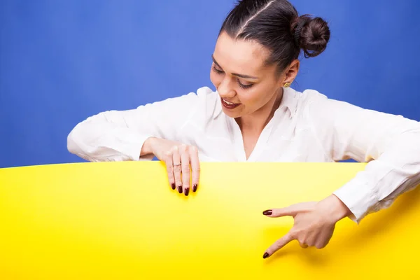 Frau zeigt mit dem Finger auf ein gelbes Banner — Stockfoto