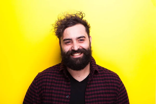 Feliz hombre hipster barbudo sonriente sobre fondo amarillo — Foto de Stock