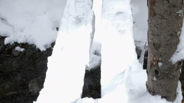 Attraversare un ponte di legno innevato su un fiume in montagna — Video Stock