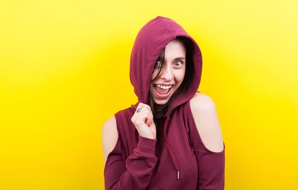 Woman makes a silly face and smiles to the camera wearing a hood — Stock Photo, Image