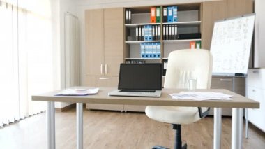 Modern boş ofis ortasında bir masa üzerine modern bir dizüstü bilgisayar