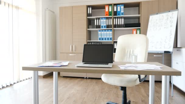 A modern laptop on a desk in the middle of modern empty office — Stock Video