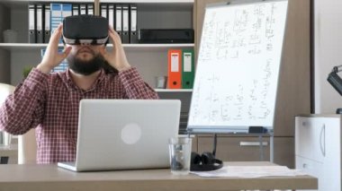 Bir ofiste sakallı adam Vr sanal gerçeklik mezartaşı--dan okul sırası alır ve başını koyar