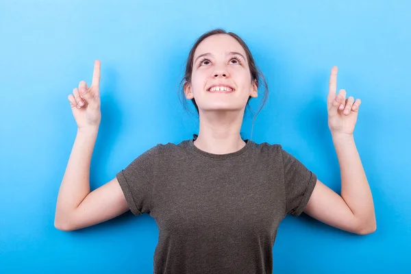 Lyckligt leende tonårig flicka pekar uppåt — Stockfoto