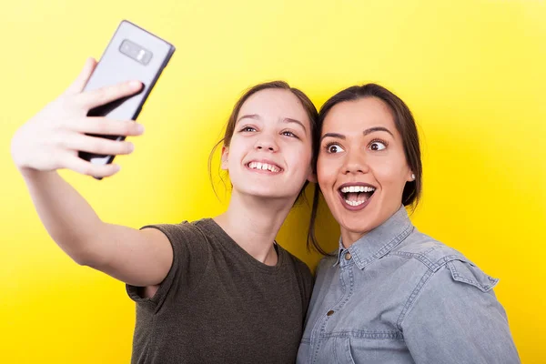 Joyeux rire et sourire sœurs prendre un selfie — Photo