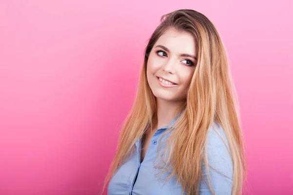 Lachende blonde vrouw op roze achtergrond — Stockfoto