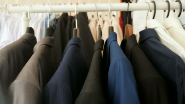 Zakelijke suits, shirts en t-shirts op een hanger — Stockvideo