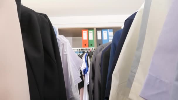Hangers doorlopen met zakelijke en casual kleding — Stockvideo