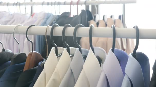 Různé obchodní oblečení, včetně košile a obleky na ramínko v obchodě