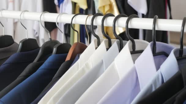 Verschiedene männliche Businessanzüge und Hemden auf Kleiderbügel — Stockvideo