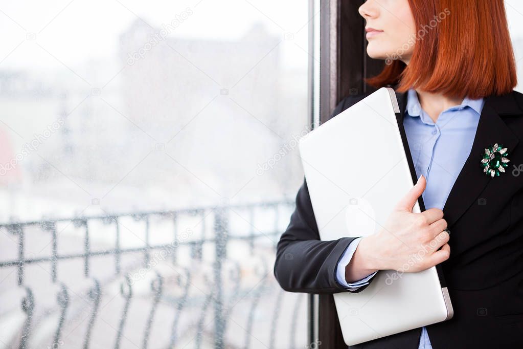 Close up of businesswoman holding a laptop in hands