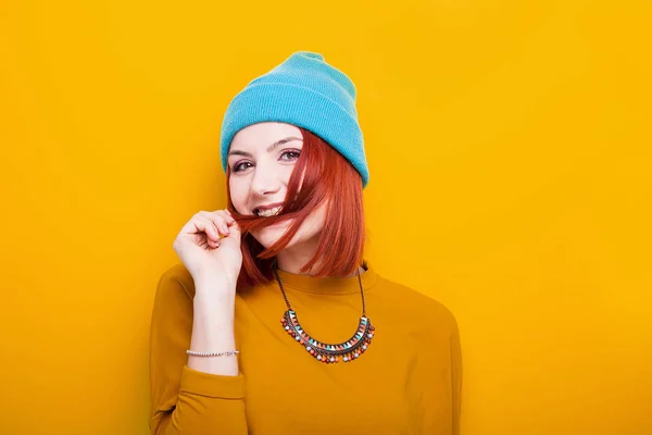 Souriante jeune femme jouant avec ses cheveux roux — Photo