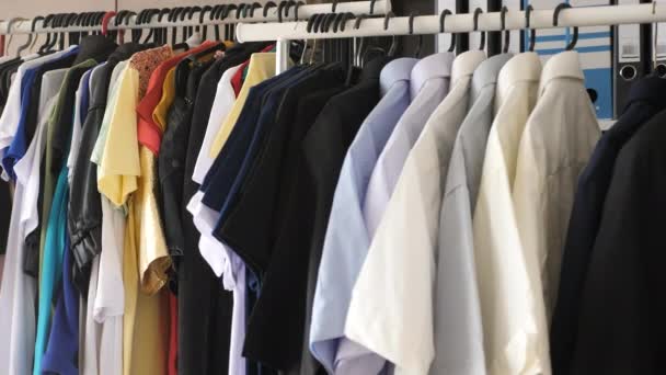 Moderní obchod s věšáky, které jsou plné různých oblečení — Stock video