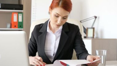 Kızıl saçlı işkadını bazı kağıtları onlara grafiklerle imzalama