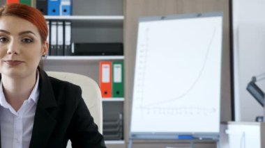 İşkadını kameraya gülümseyen resmi elbiseli