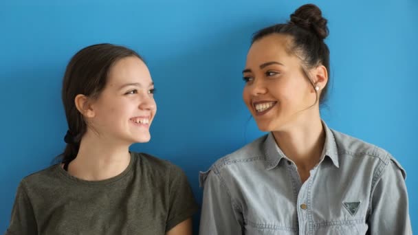 Jüngere und ältere Schwester schauen einander an und lachen — Stockvideo