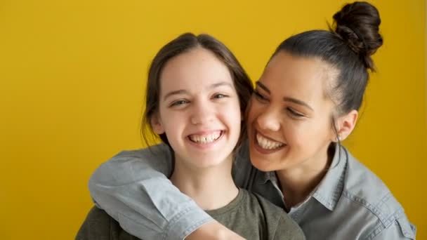 Felices hermanas riendo sobre fondo amarillo — Vídeo de stock