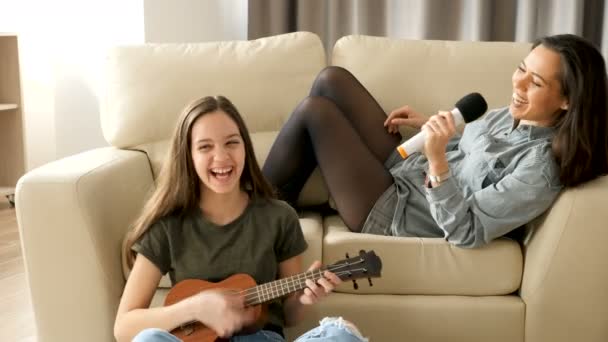 Hermana menor y mayor cantando en la sala de estar — Vídeo de stock