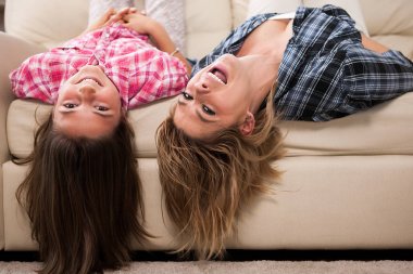 Sevimli kızıyla kanepede kafalarını ile baş aşağı yalan birlikte güzel annem